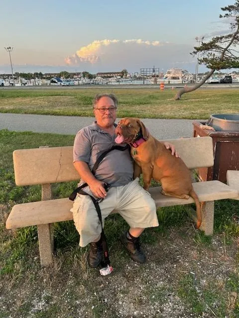 Robert sitting with his dog on a bench outdoors